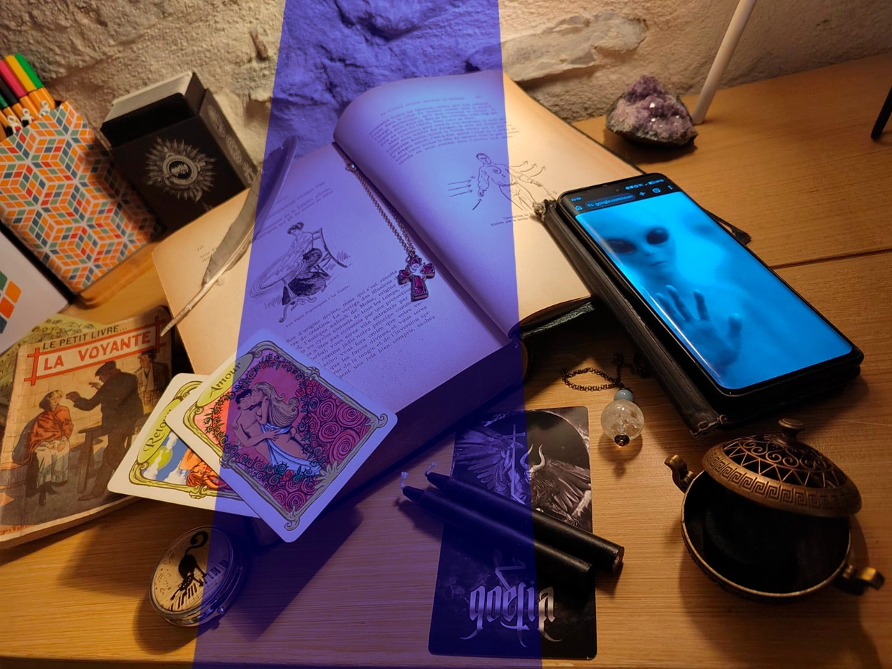 photo avec des objets issus de croyances mélangées (cartes, alien, encens, pendule....)