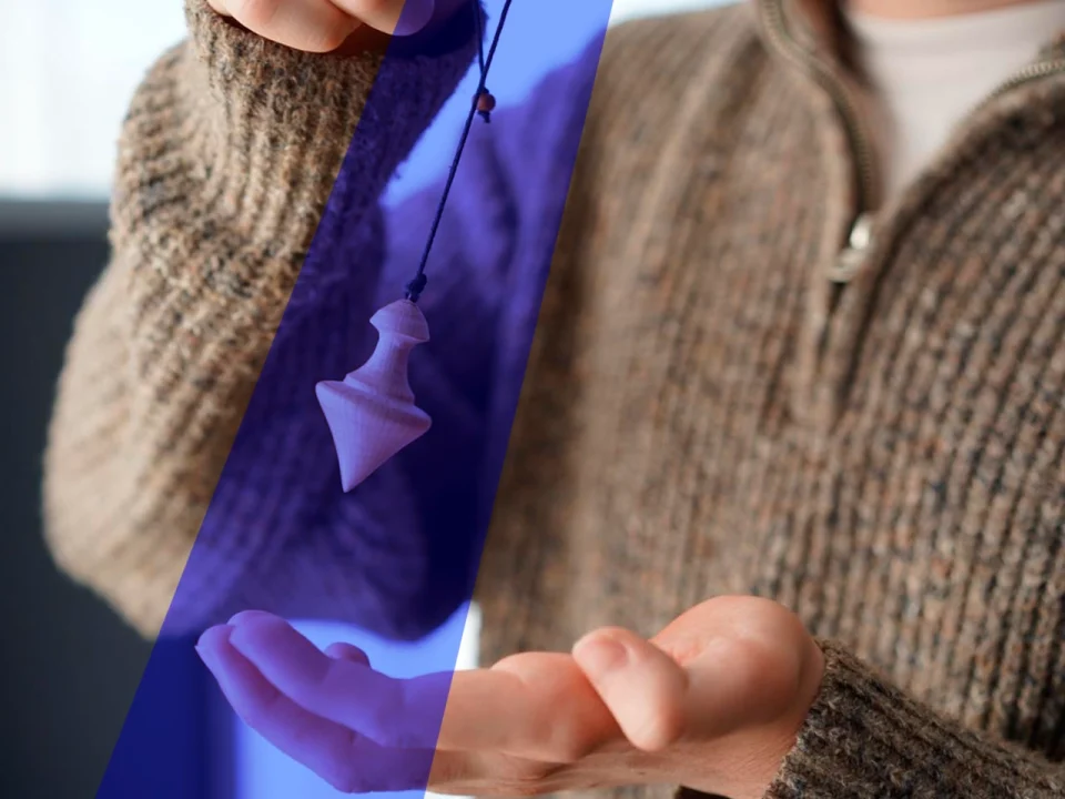 Homme avec un pendule en bois dans les mains